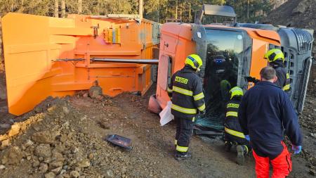 Pracovní stroj se překlopil při vysypání nákladu. Pro řidiče letěl vrtulník